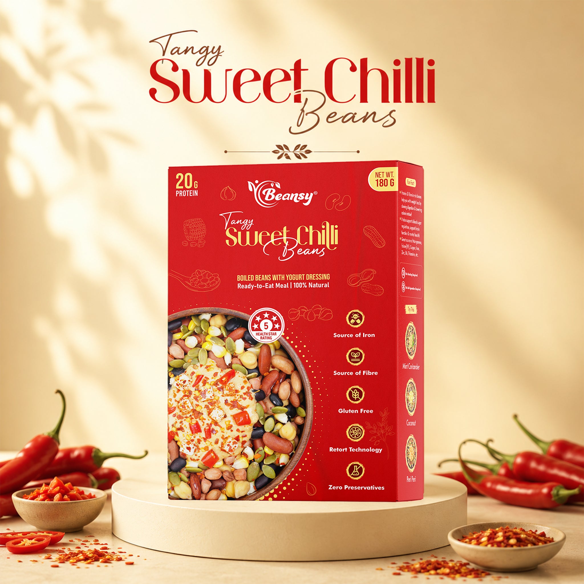 Box of 'Tangy Sweet Chilli Beans' with chili peppers and beans on a wooden surface.