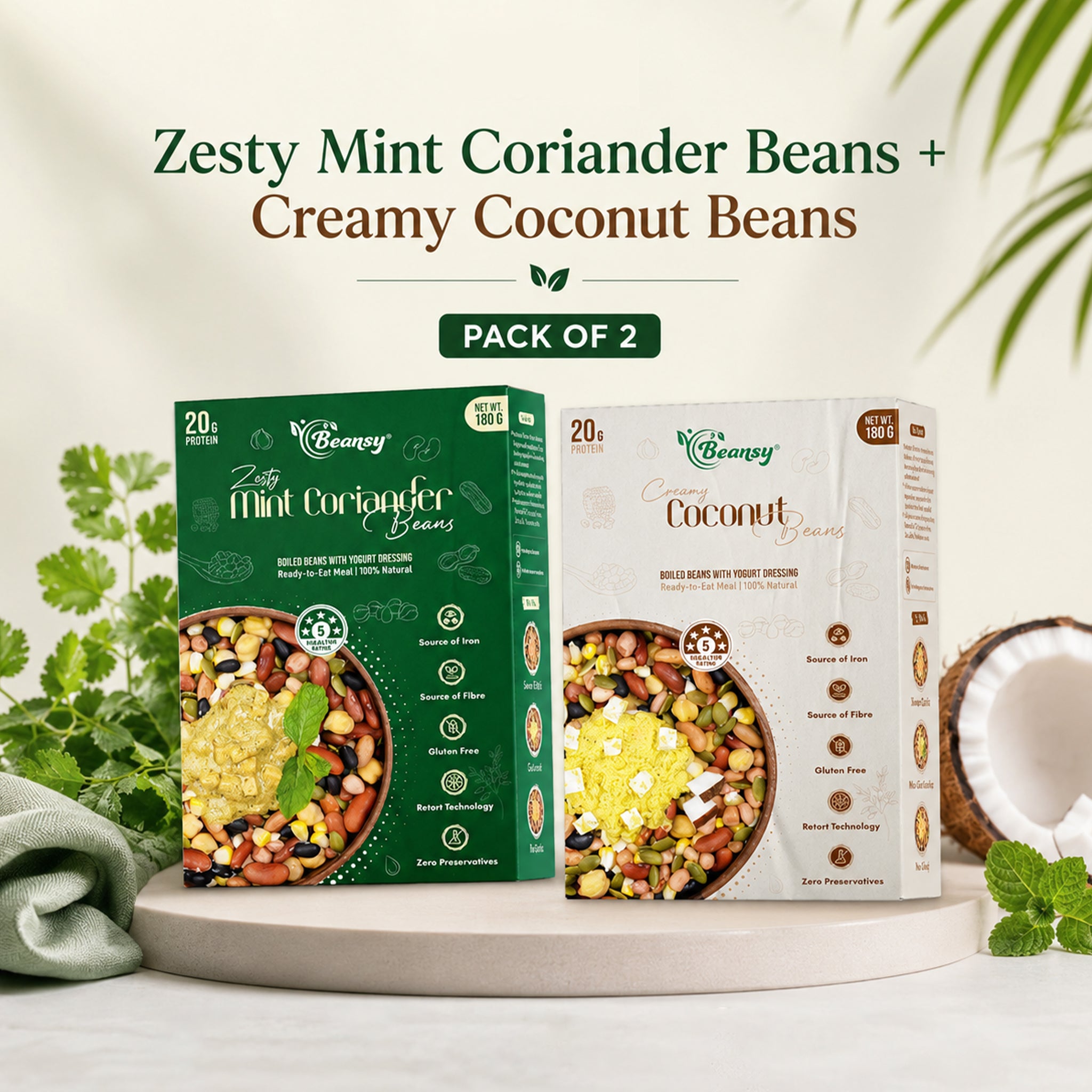 Two boxes of Zesty Mint Coriander Beans and Creamy Coconut Beans on a white surface with greenery in the background.
